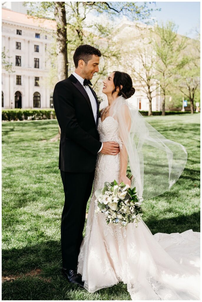 bride and groom posing in a park